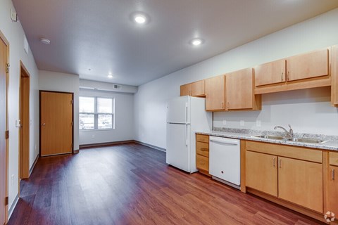 A kitchen with wooden floors and cabinets.