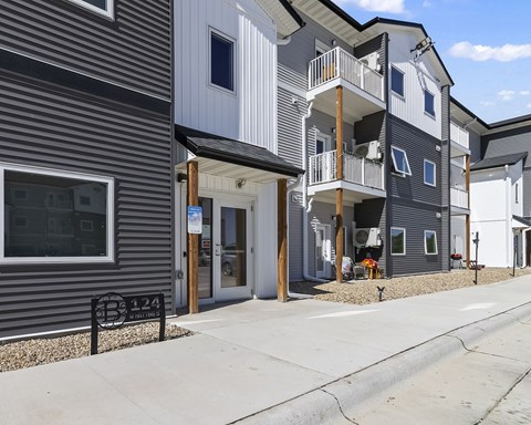 a row of houses with a sidewalk and a bench