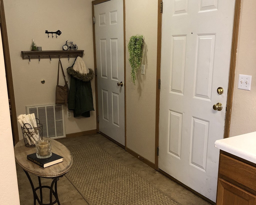 a bathroom with two white doors and a table with a plant on it