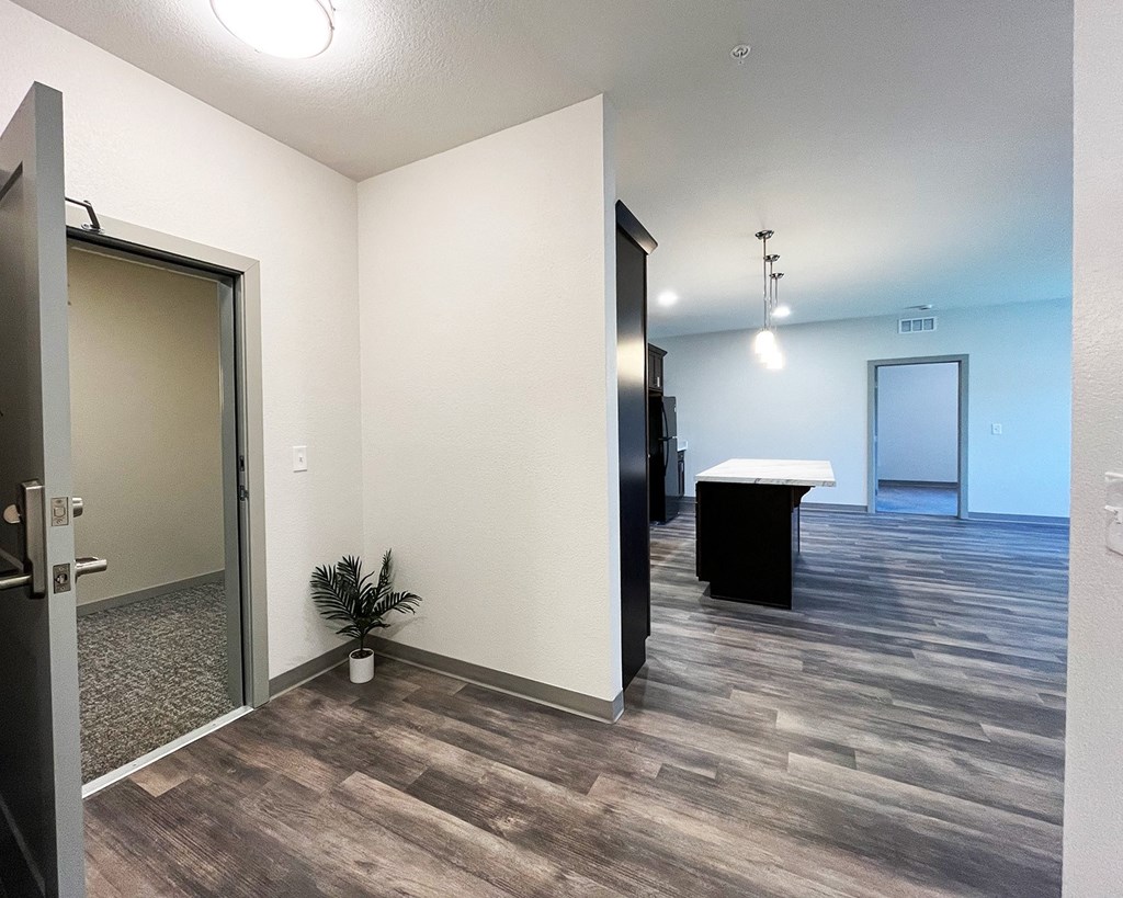 an empty hallway with a door to a room and a table