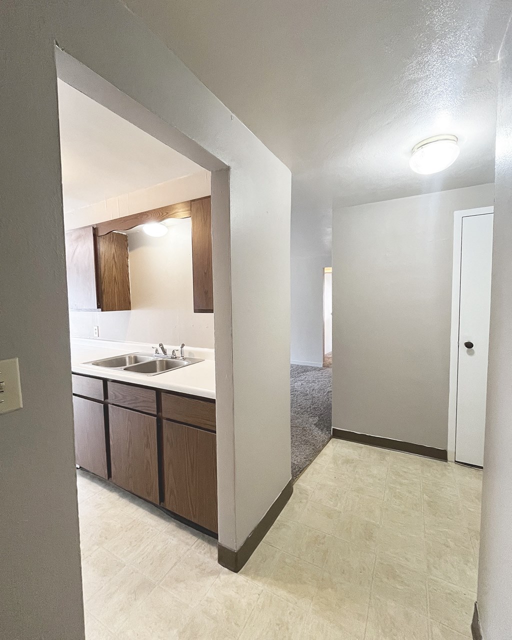 an empty kitchen with a sink and a mirror