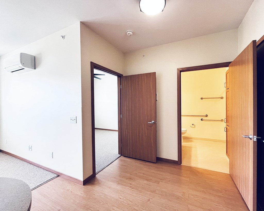 A room with a brown door and a white wall.