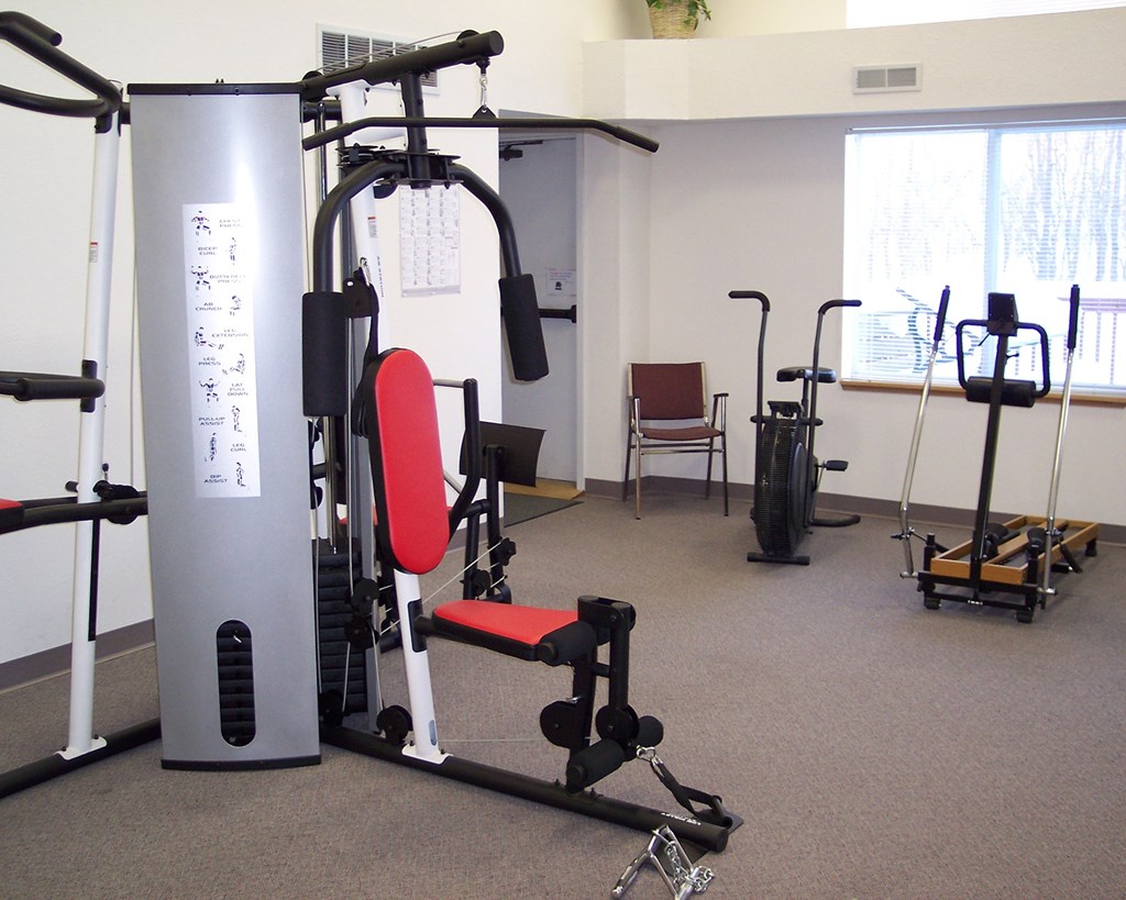 A gym with a variety of equipment including a leg press machine.