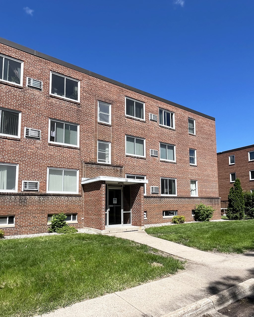 a red brick building with a sidewalk in front of it