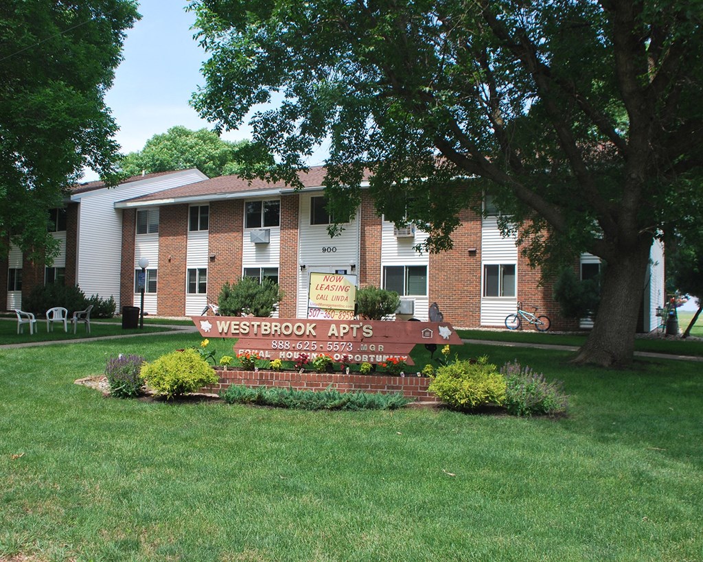 a view of the apartments sign in front of the building