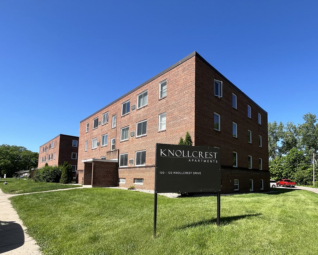 a tall brick building with a sign in front of it