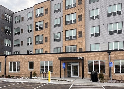a brick building with a parking lot in front of it