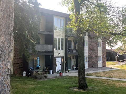 an apartment building with a tree in front of it