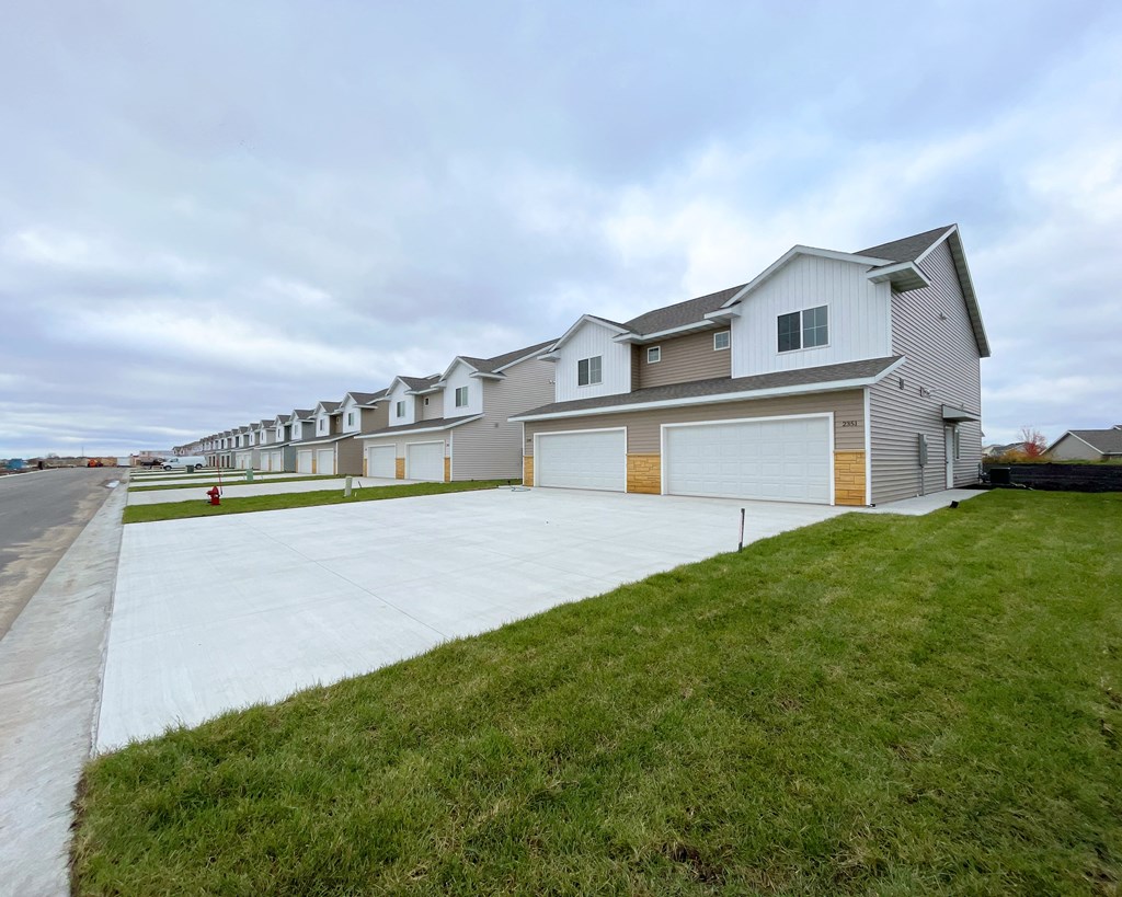 a house with a driveway and a row of garage doors