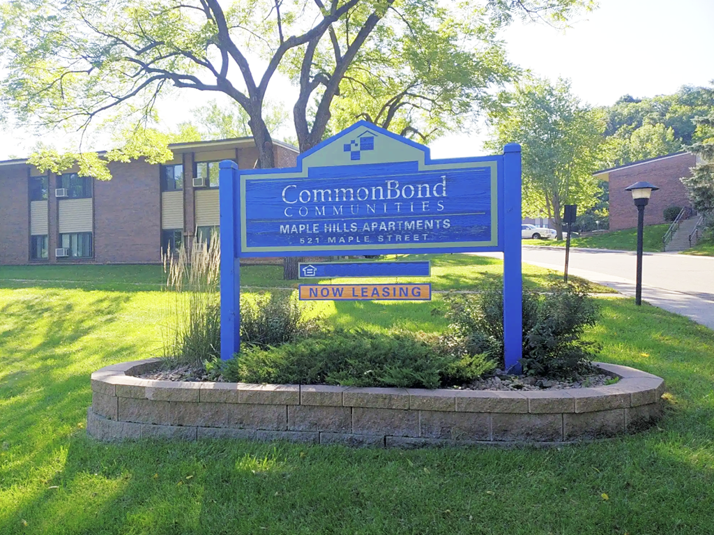 A sign for CommonBond Communities is displayed in front of a building.
