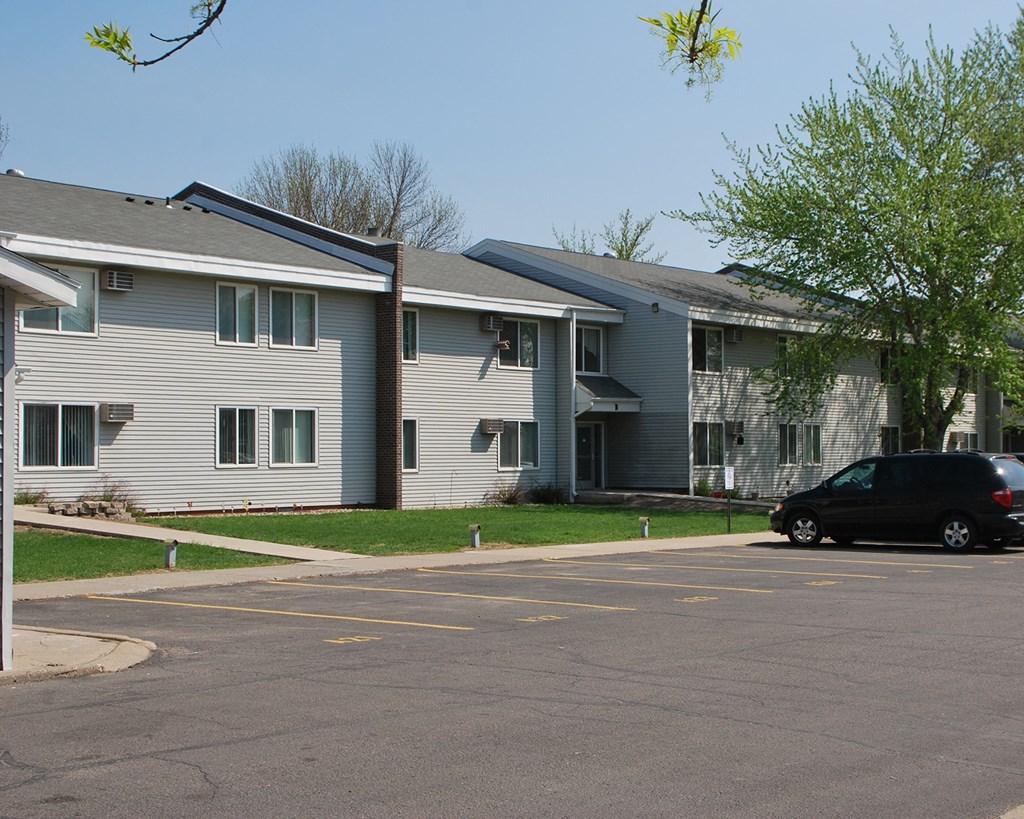 a car parked in a parking lot in front of an apartment building