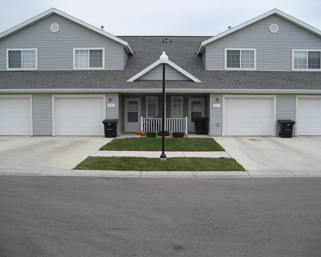 a house with a street light in front of a driveway