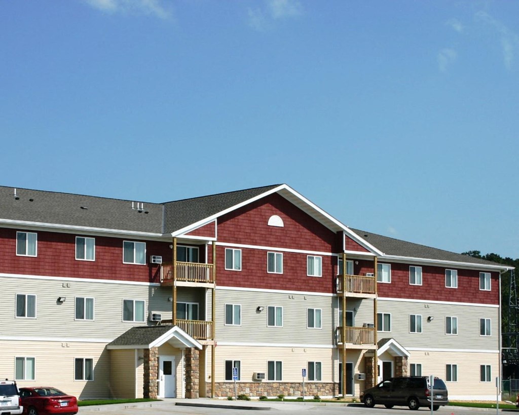 a large apartment building with cars parked in front of it