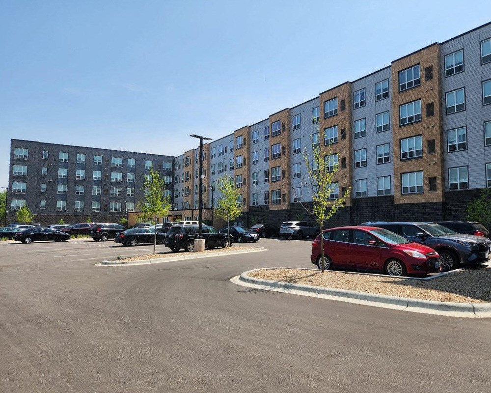 a parking lot with cars in front of a large building