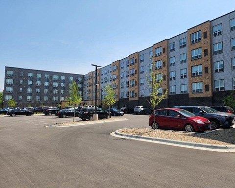 a parking lot with cars in front of a large building