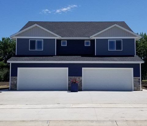 a house with two garage doors in front of it