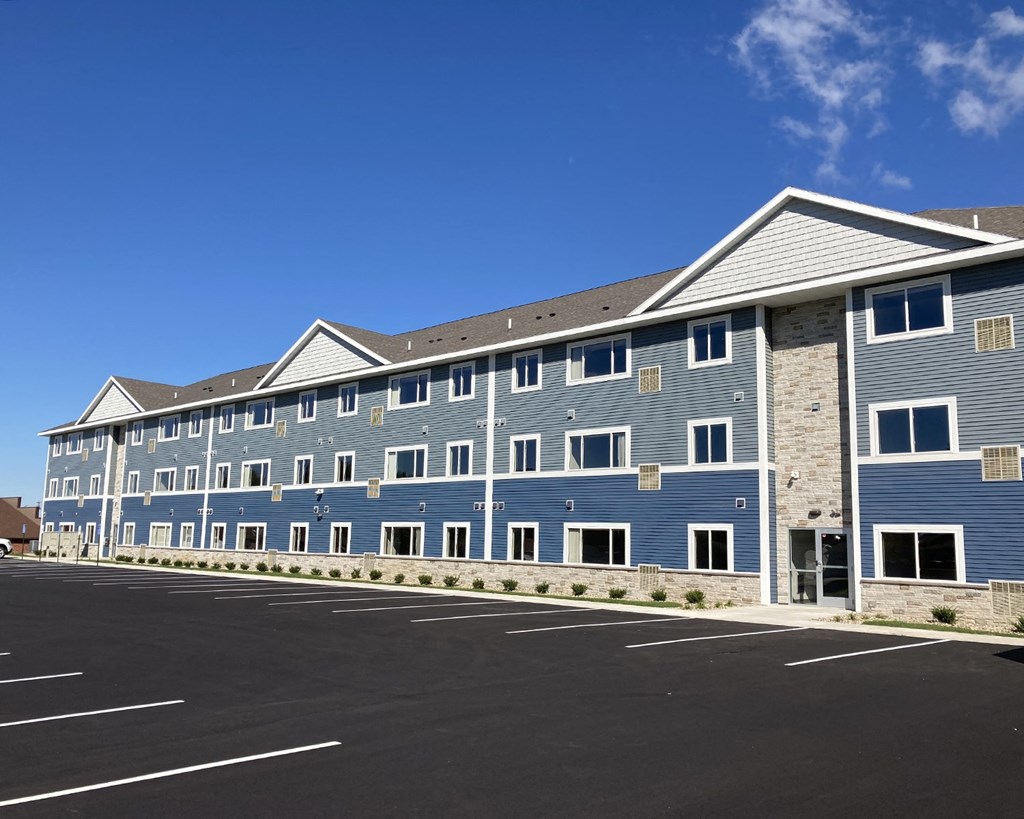 a large blue building with a street in front of it
