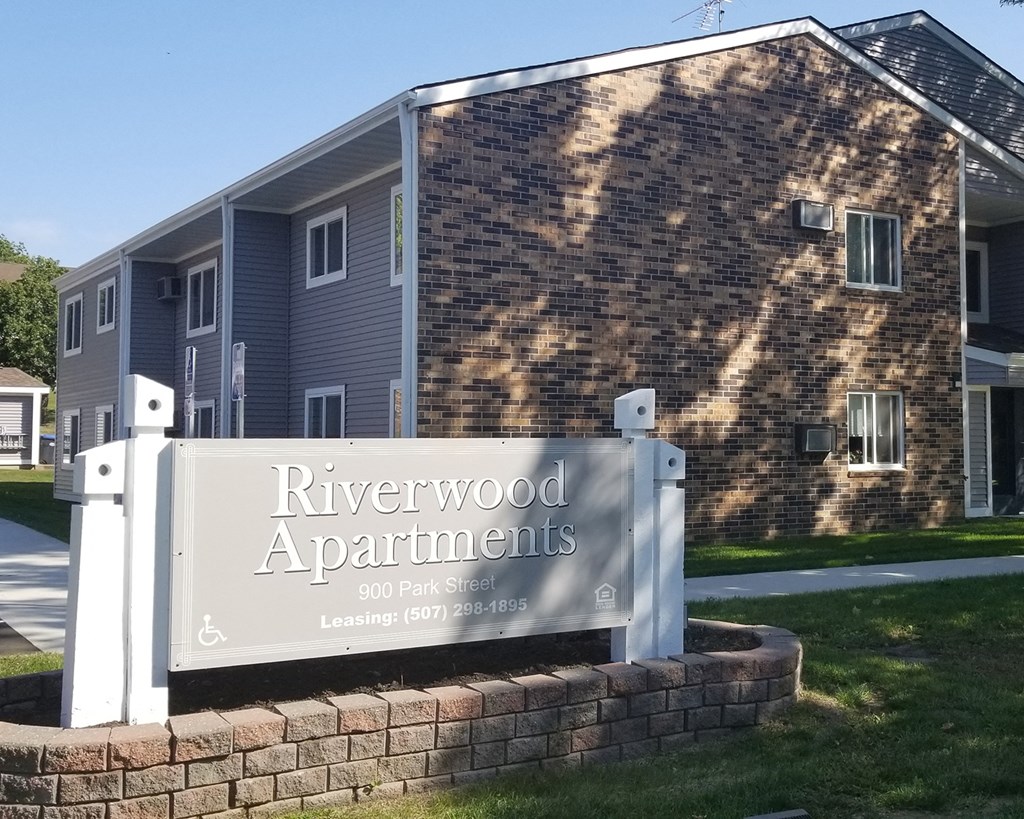 a sign for riverwood apartments in front of a building