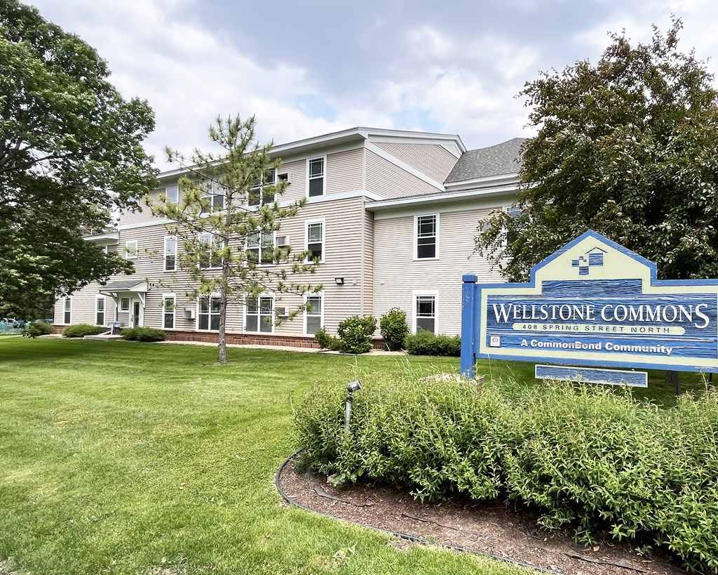 A sign for Wellstone Commons is in front of a building.