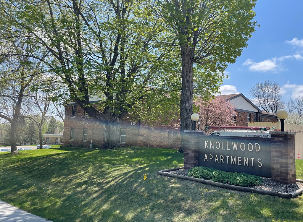 the entrance to kohlwood apartments with trees and a sign