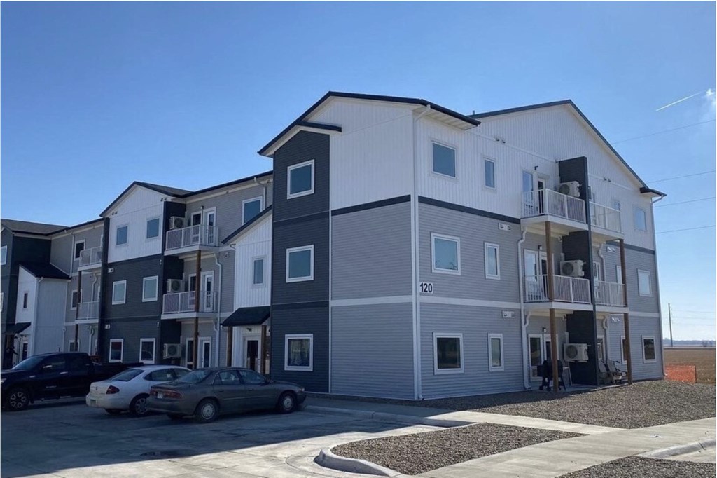 a large apartment building with cars parked in front of it