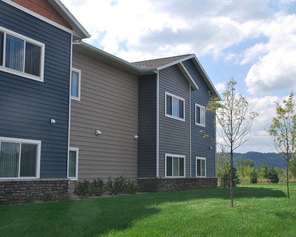 a house with gray siding and a green lawn