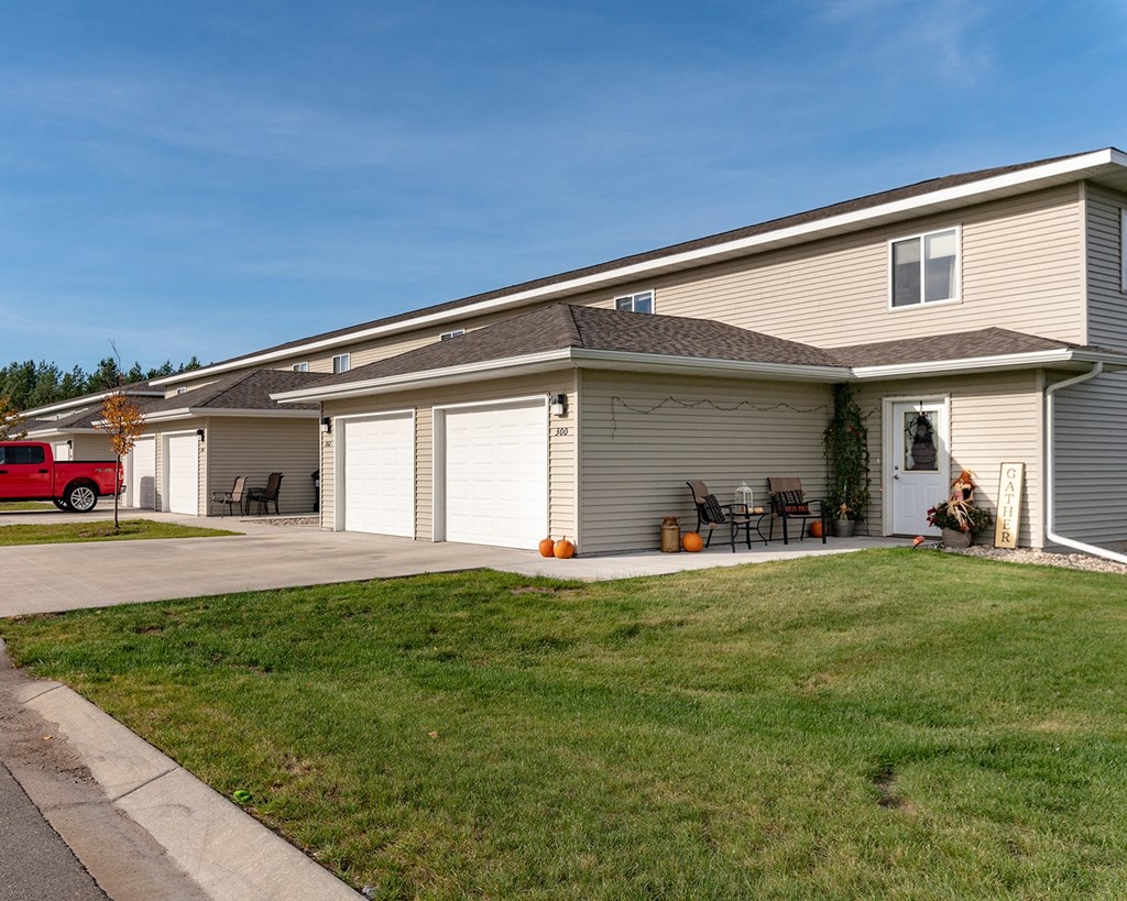 the front of a house with a driveway and lawn