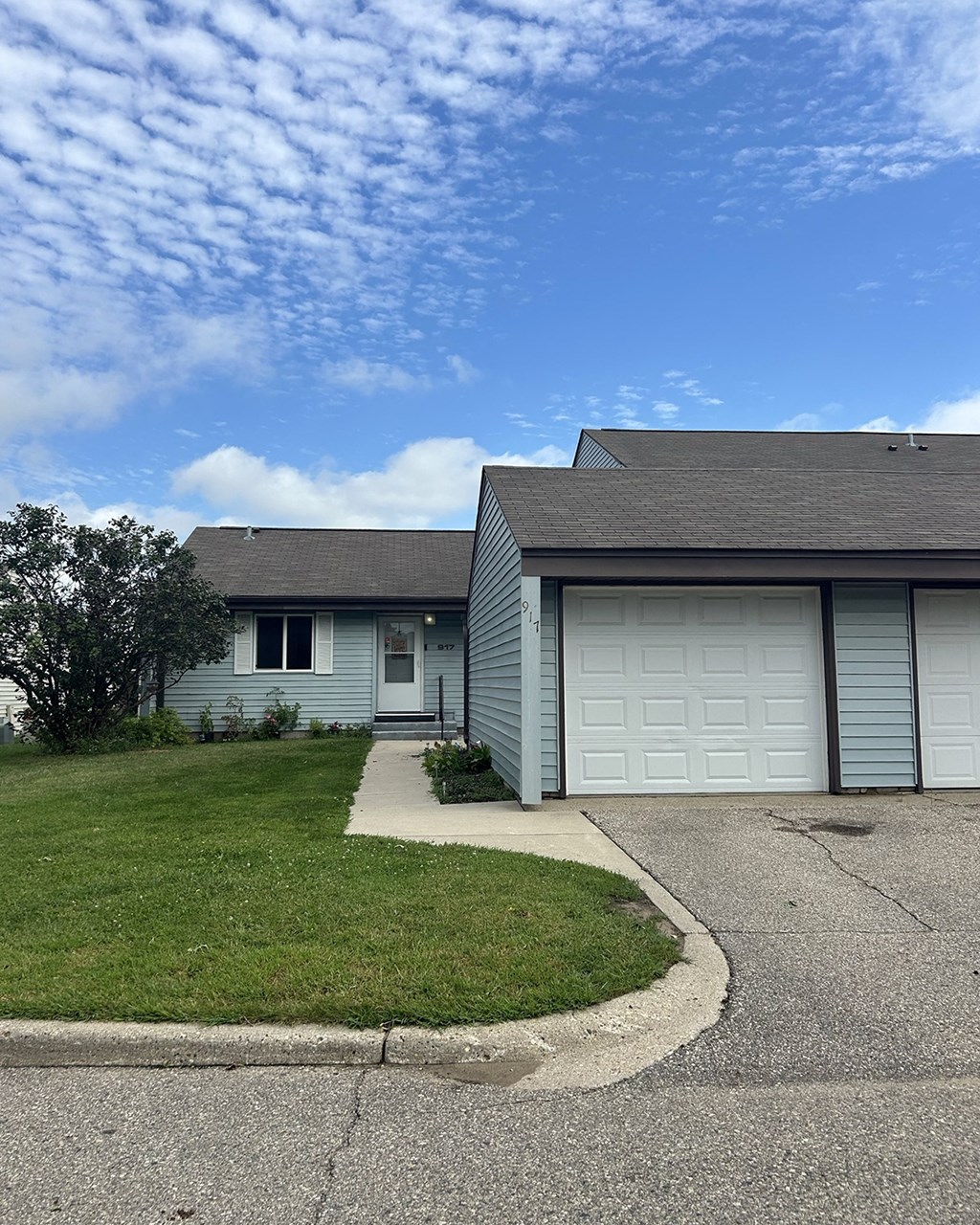 A house with a grey roof and a white garage door.