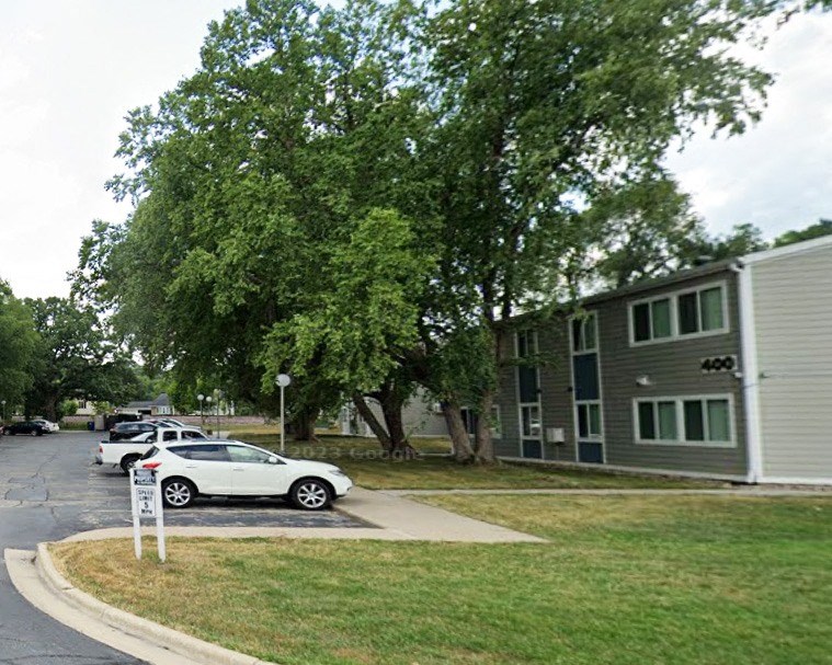 a row of cars parked in front of an apartment building
