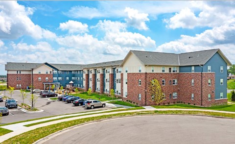 A large building with a parking lot in front.