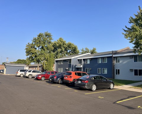 a parking lot full of cars in front of a building