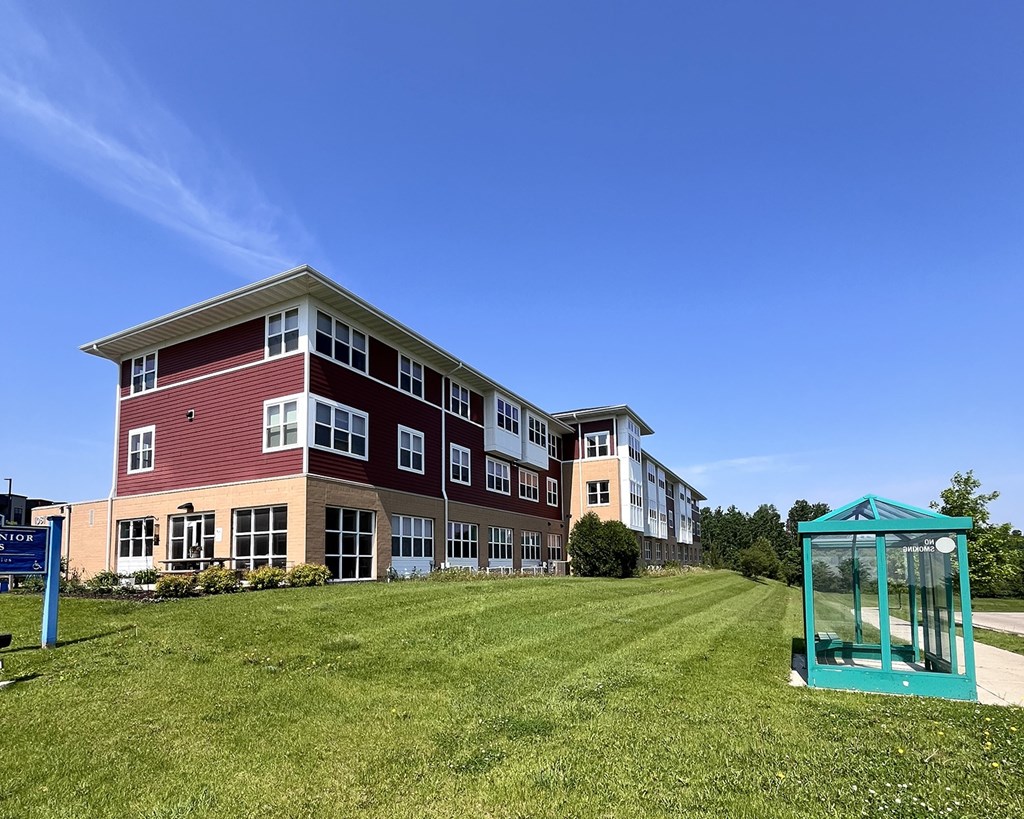 A red and white building with a blue bus stop in front.