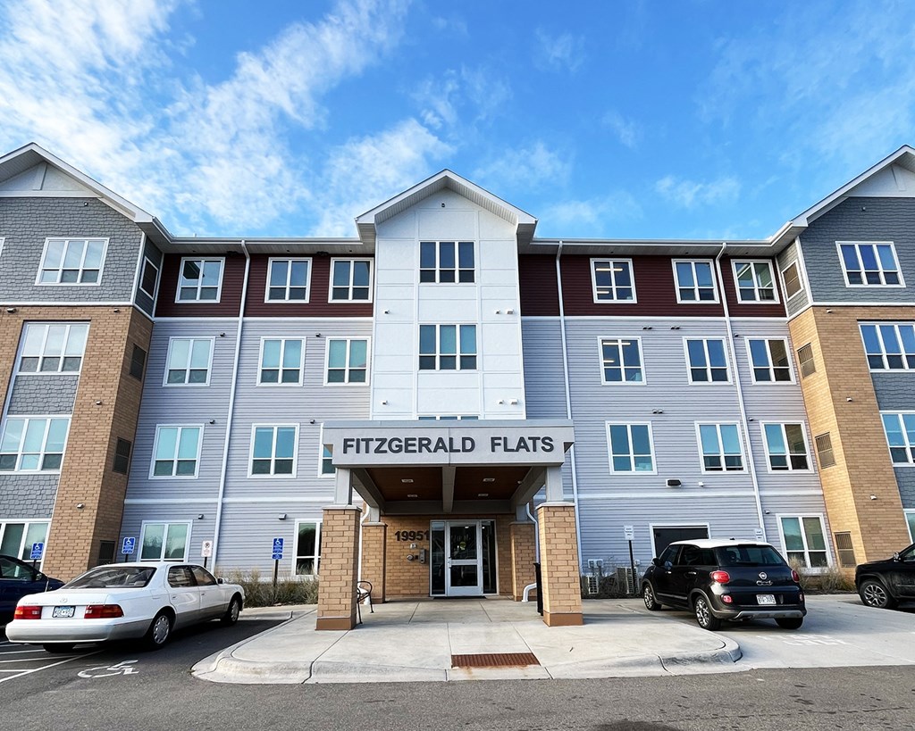 Fitzgerald Flats is a multi-story residential building with cars parked in front.