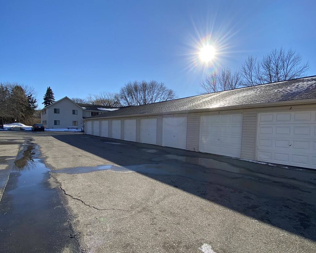 a white garage with the sun shining above it