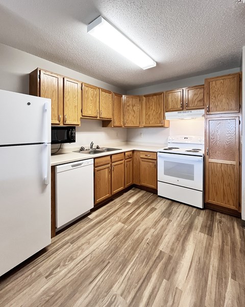 A kitchen with wooden cabinets and white appliances.