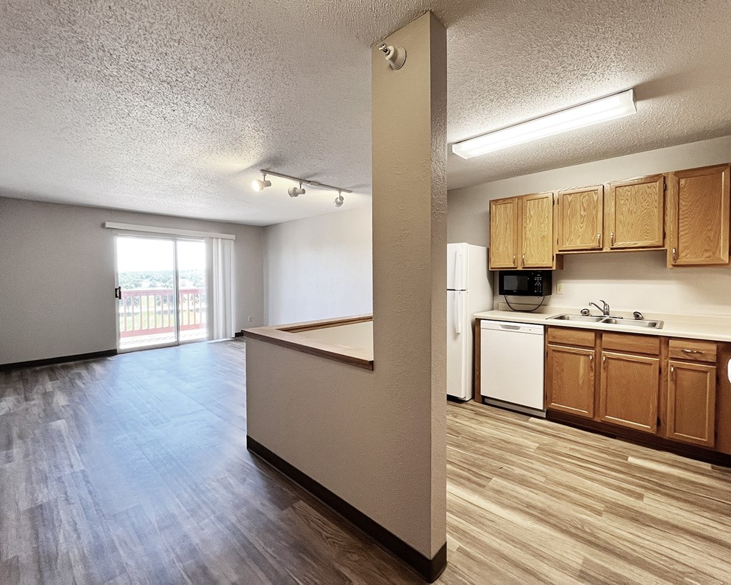 A kitchen area with wooden cabinets and a white dishwasher.