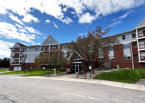A large apartment complex with a parking lot in front.