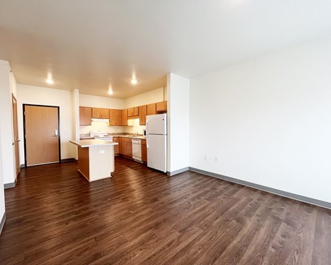 A kitchen with wooden floors and white walls.