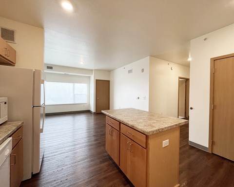 A kitchen with wooden cabinets and a marble countertop.