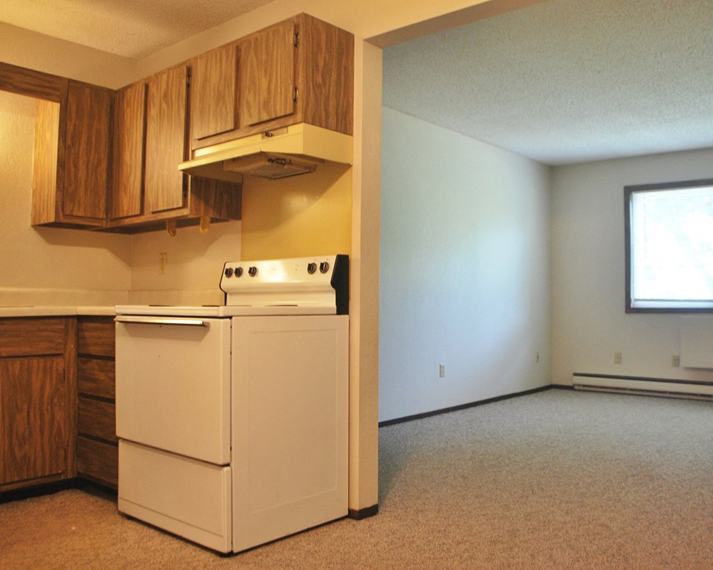 an empty kitchen with a stove and a refrigerator