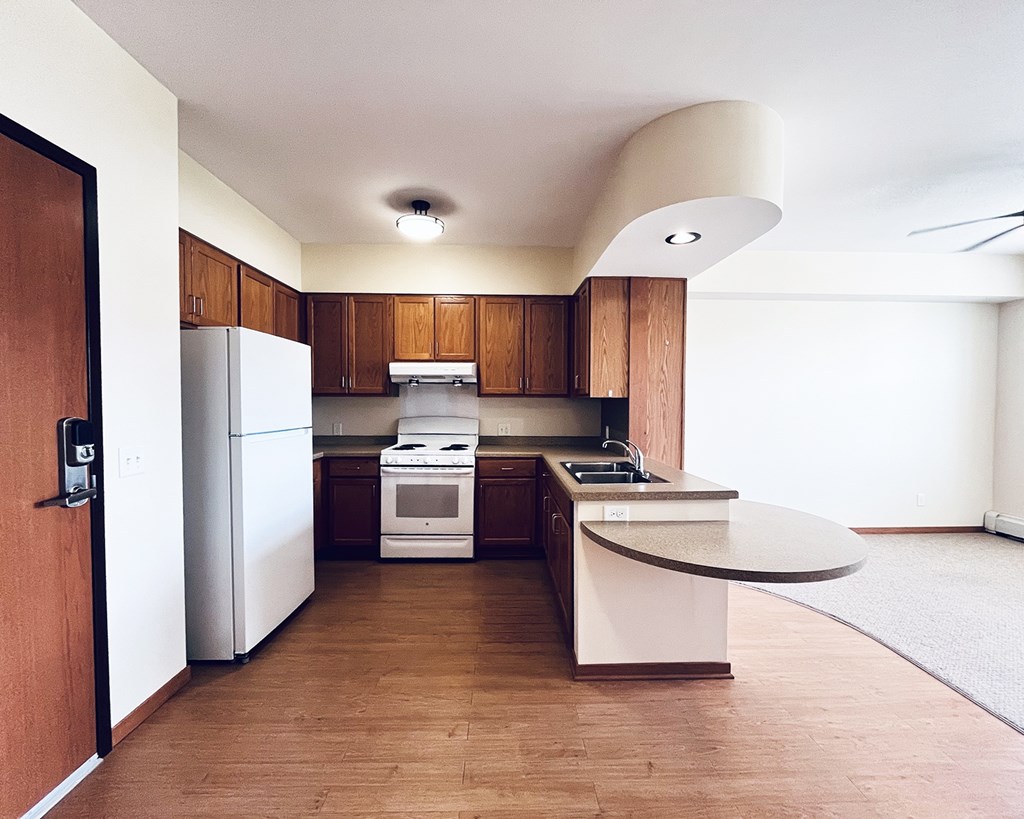 A modern kitchen with wooden cabinets and white appliances.