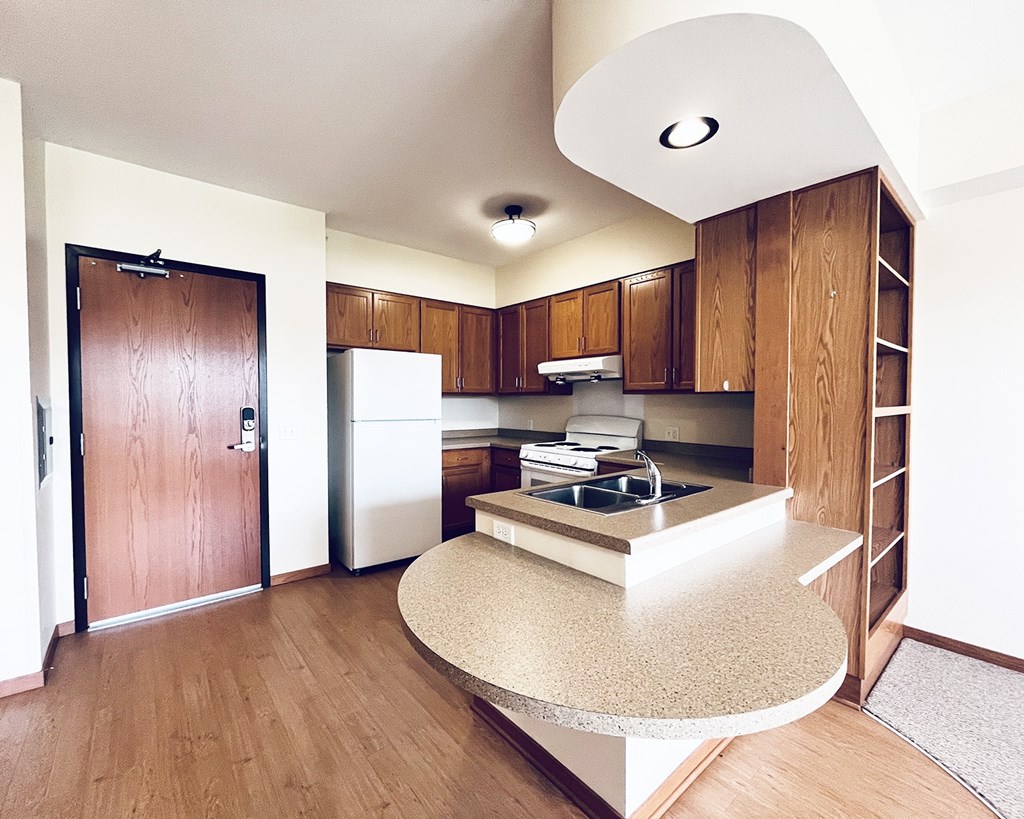 A kitchen with wooden cabinets and a white fridge.