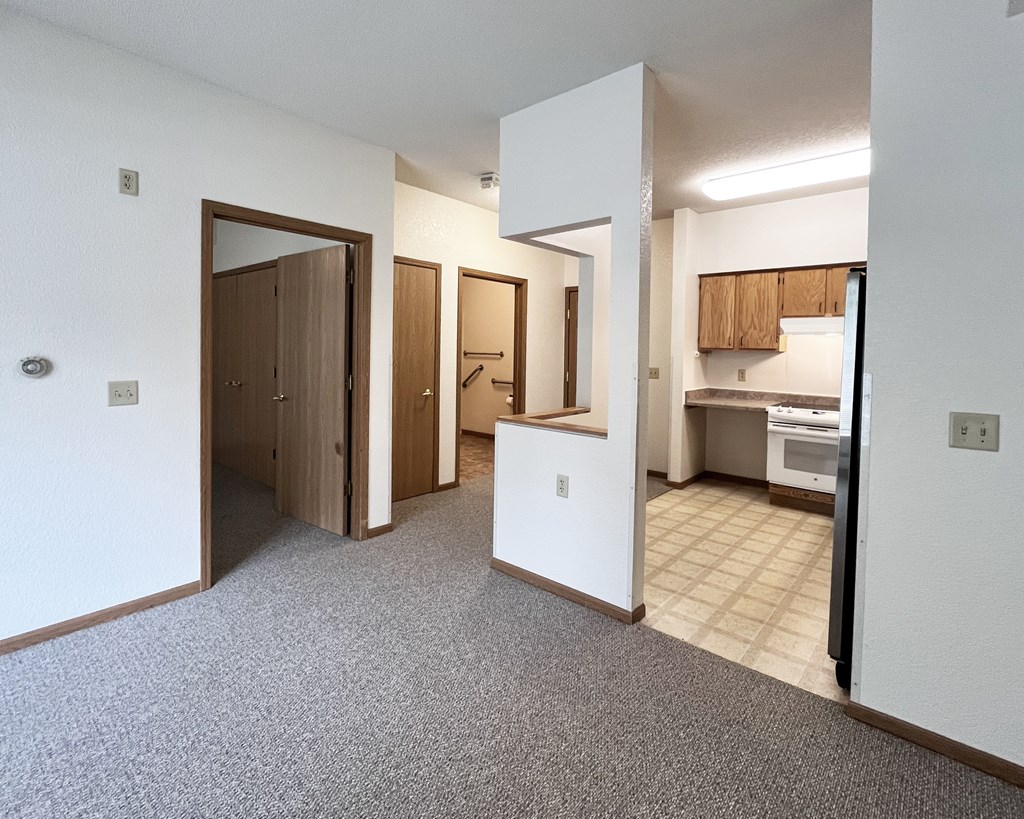 A kitchen area with a refrigerator, oven, and cabinets.
