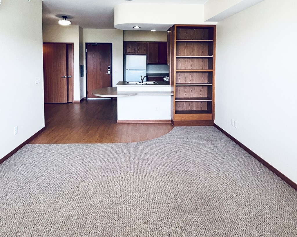 A kitchen with a white counter top and a wooden floor.