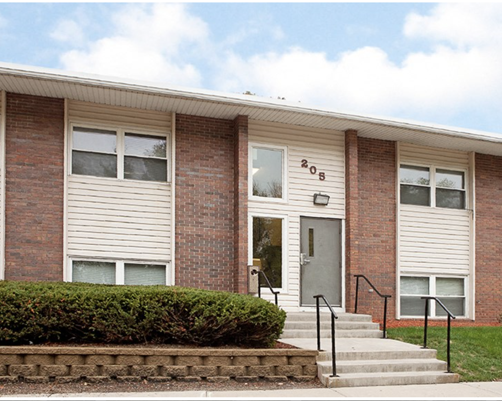 A brick building with a grey door and windows.