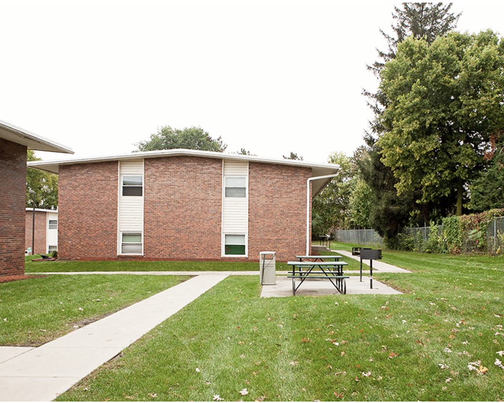 A brick building with a picnic table in front of it.