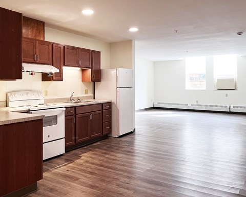 A kitchen with brown cabinets and white appliances.