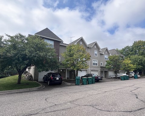 A parking lot in front of a residential building.