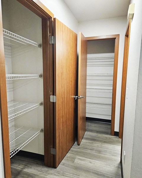 A walk in closet with shelves and doors.