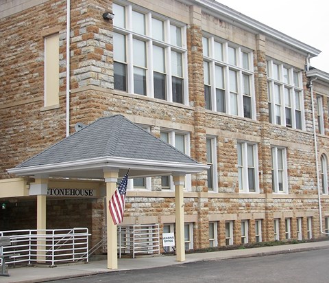 A building with a stone facade and a covered entrance.